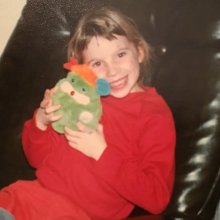 Caitlin as a child hugging a stuffed toy
